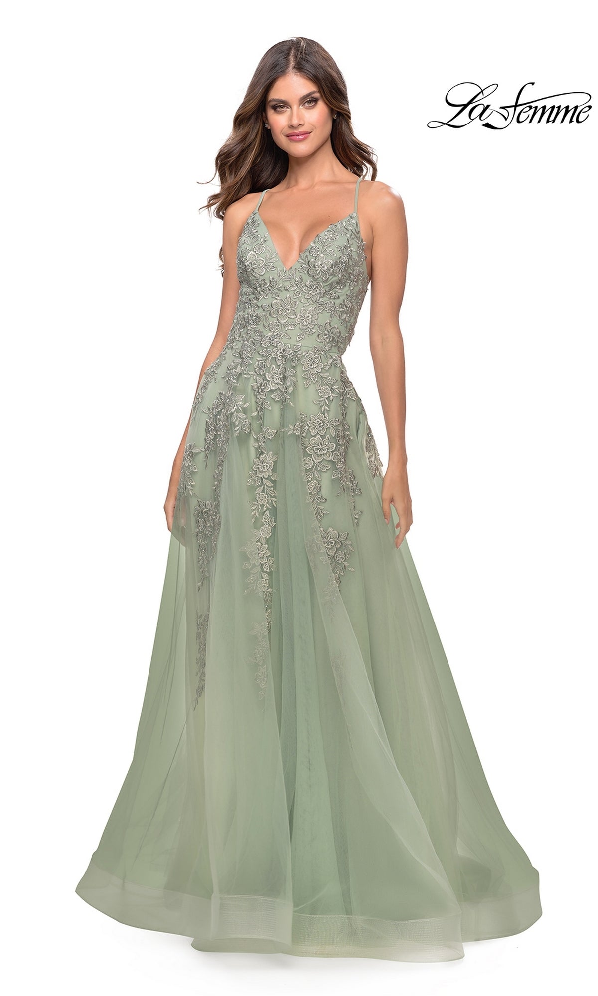 A woman wears the La Femme Strappy-Back Long A-Line Prom Dress 31503 in light green, featuring spaghetti straps, floral lace embroidery, and a flared tulle skirt. The La Femme logo is displayed in the top right corner.